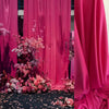Pink and magenta stretch jersey fabric draped as a backdrop with floral accents