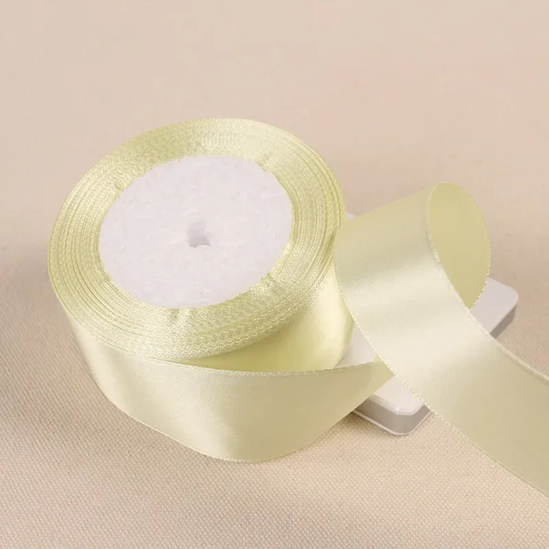 A roll of pale yellow satin ribbon used for gift wrapping and crafts.