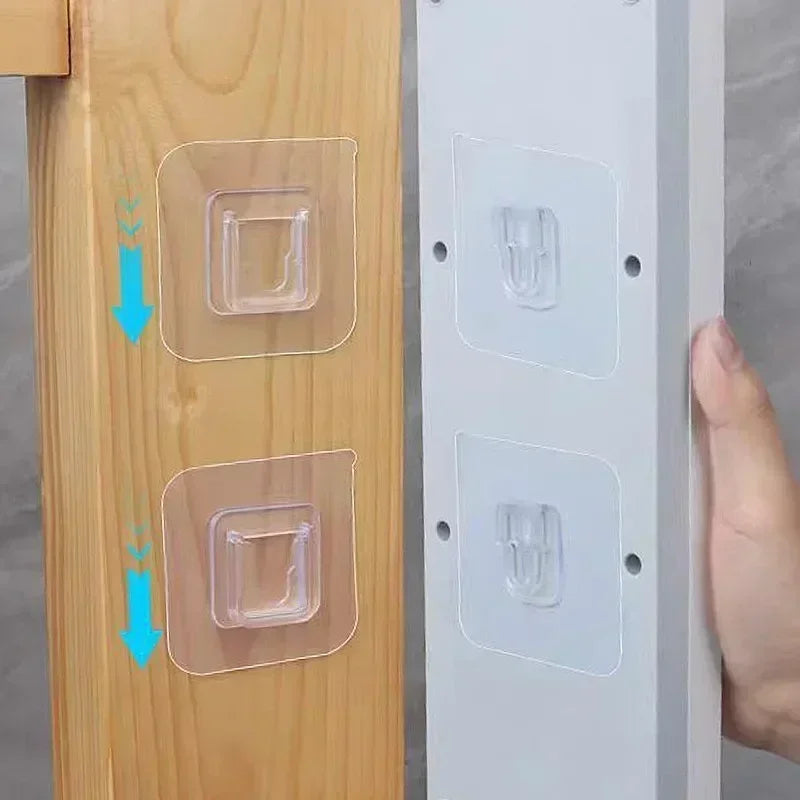 Two clear double-sided adhesive wall hooks are shown being installed on a wooden panel and a white surface.