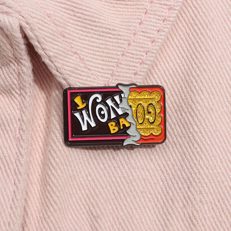 A vintage airline ticket enamel brooch set featuring gold and black details on a pink fabric background.