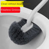 A gray toilet brush with a flexible handle is shown inside a white toilet bowl.