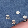 Close-up of blue denim fabric with silver metal button snaps used for adjusting waistlines.