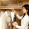 A woman hangs silk scarves, hats, and belts on a wooden hanger in a vertical space-saving closet organizer.