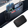 A black organizer bag with a side pocket holding various electronic devices and cards inside a car seat.