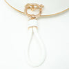 Gold-toned key fob cover with a white cord and loop for a Nissan car key.