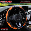 Orange and black carbon fiber steering wheel cover for a car, shown inside the vehicle cockpit.
