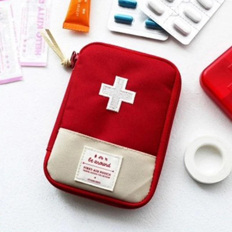 A red pouch with a white cross and a beige pocket is shown next to various first-aid supplies.