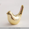 A small, golden ceramic elephant and rabbit jewelry holder with a smooth, curved design.