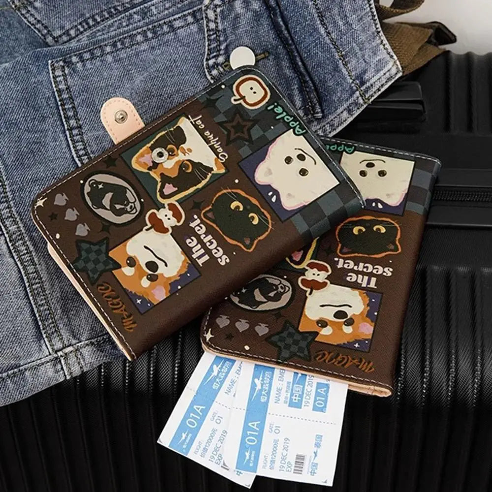 A brown leather passport holder with cartoon animal designs is placed on a denim jacket.