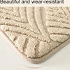 A close-up view of a beige plush velvet bathroom mat with a textured, non-slip surface.