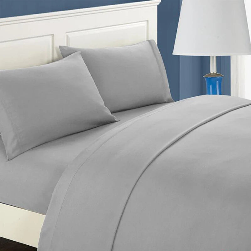 A gray bedding set featuring a fitted sheet, flat sheet, and pillowcases on a bed with a white headboard.