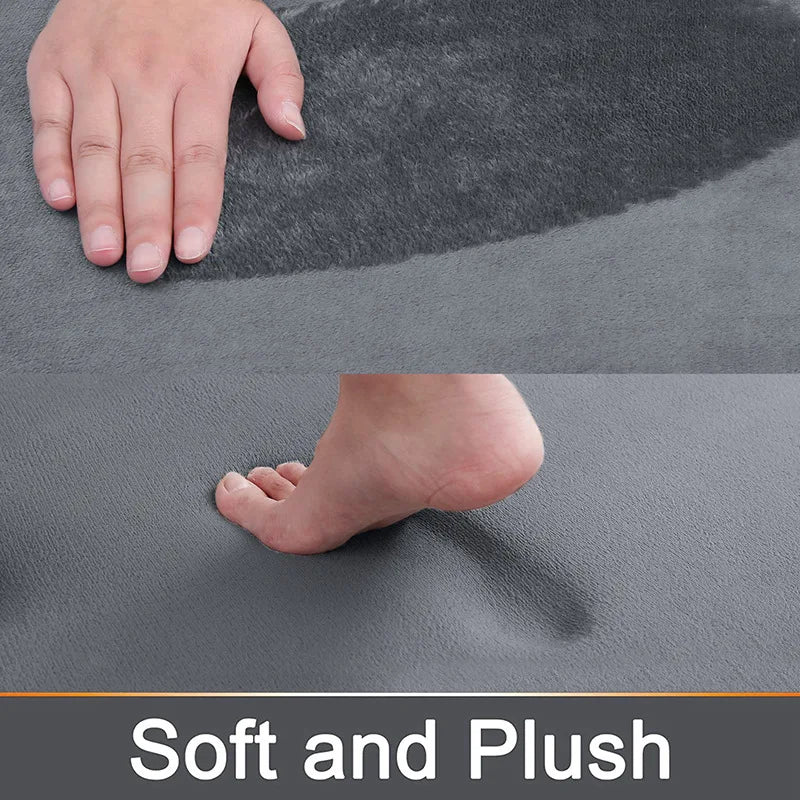 Close-up view of a gray plush memory foam bathroom mat showing a hand and foot pressing into the soft surface.