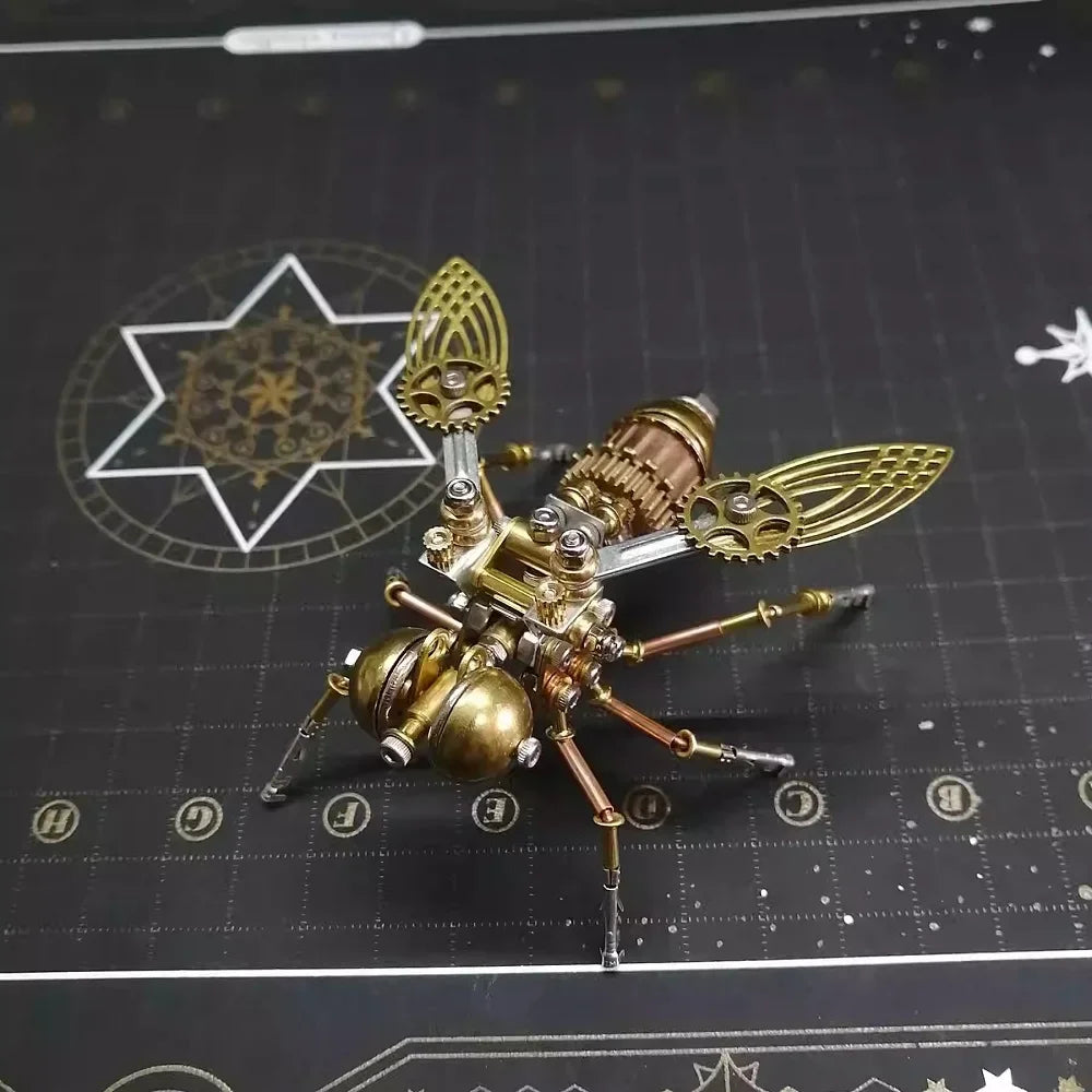 A detailed brass metal insect puzzle decor with wings and legs is displayed on a dark surface.