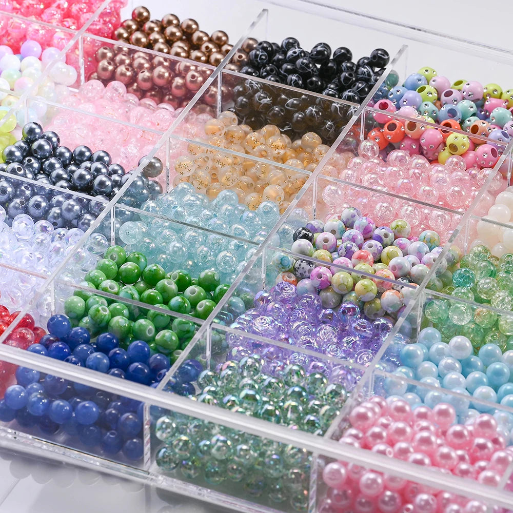 A clear box filled with various mixed acrylic beads in multiple colors and styles for jewelry making