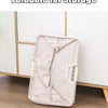 A beige foldable laundry basket with handles is shown standing on a wooden floor.