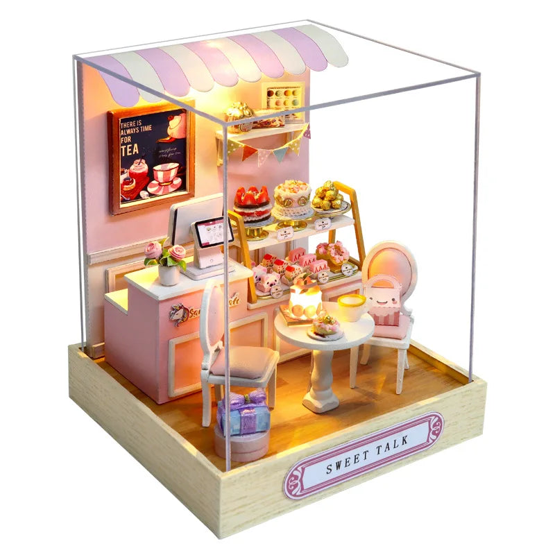 A miniature dollhouse kit featuring a pink and purple facade with interior details, including furniture and food items.