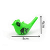 A bright green plastic novelty bird whistle toy with floral designs, shown with dimensions.