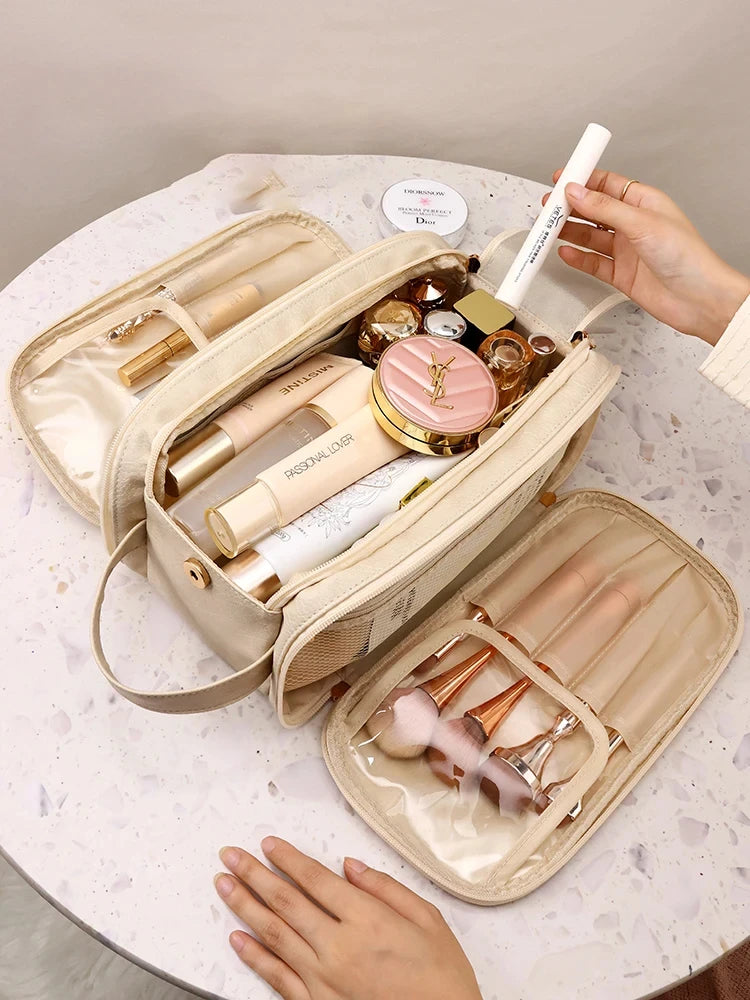 A beige cosmetic bag is open, displaying various makeup and skincare products like lipsticks and foundations on a white marbl