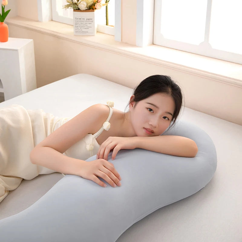 Una mujer yace en una almohada lateral de onda ergonómica gris.