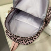 A light purple leopard print nylon backpack is shown open, displaying the interior lining and exterior design.