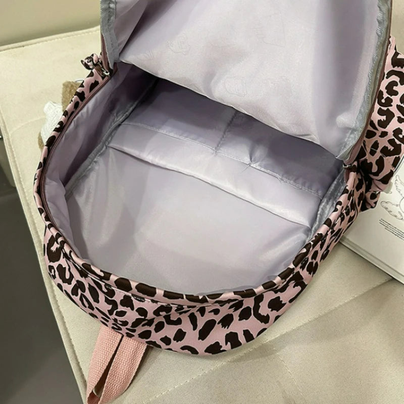 A light purple leopard print nylon backpack is shown open, displaying the interior lining and exterior design.