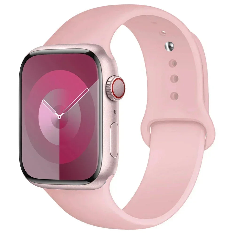 A pink silicone sport band worn around an Apple Watch.