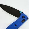 A black folding pocket knife with a drop point blade and blue handle is shown from the side.