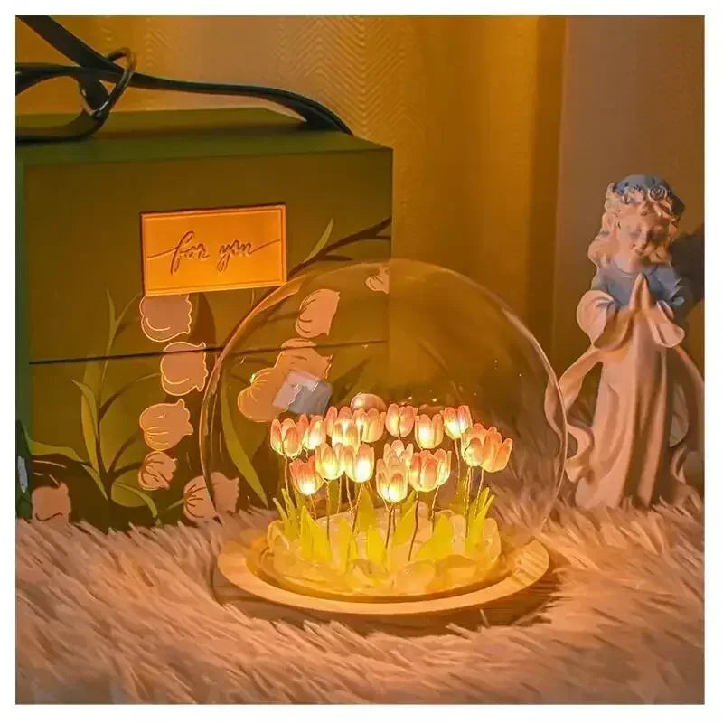 A handcrafted tulip LED night light with a wooden base sits on a fuzzy surface next to a green box.