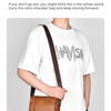 A man wearing a white t-shirt and jeans carrying a brown vintage leather messenger bag across his body.