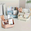 A light pink desktop organizer holding various office and school supplies like pens, pencils, and notebooks.