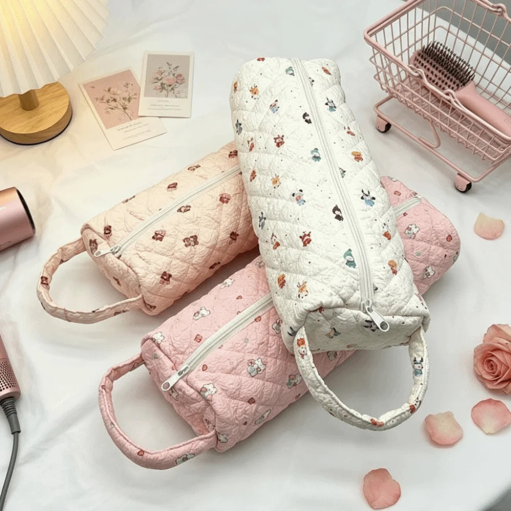 A collection of pink and white quilted cotton storage bags with handles displayed on a white surface.