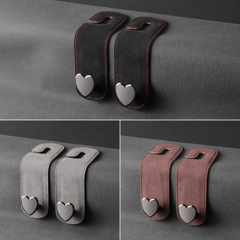 Two black car seat headrest hooks with heart-shaped grips for bags and phones