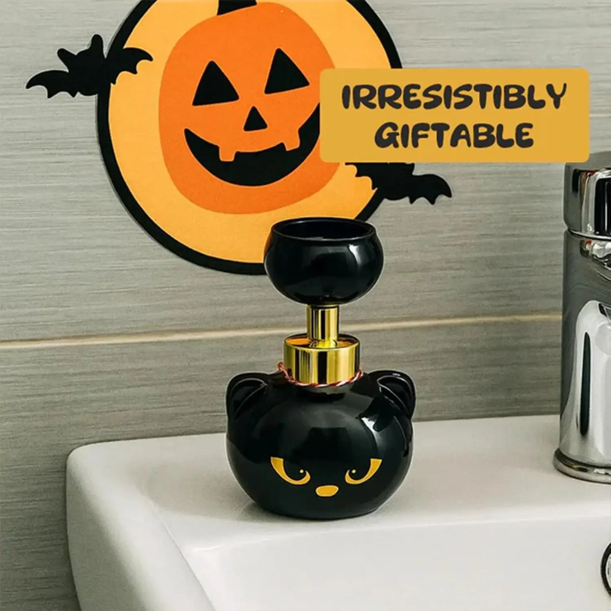 A black cat paw shaped foam soap dispenser with a gold top sitting on a white sink.