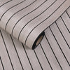 Roll of 3D grille pattern peel-and-stick wallpaper showing vertical black lines on a light gray background