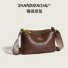 A brown PU leather crossbody shoulder bag with a patterned strap and gold hardware.