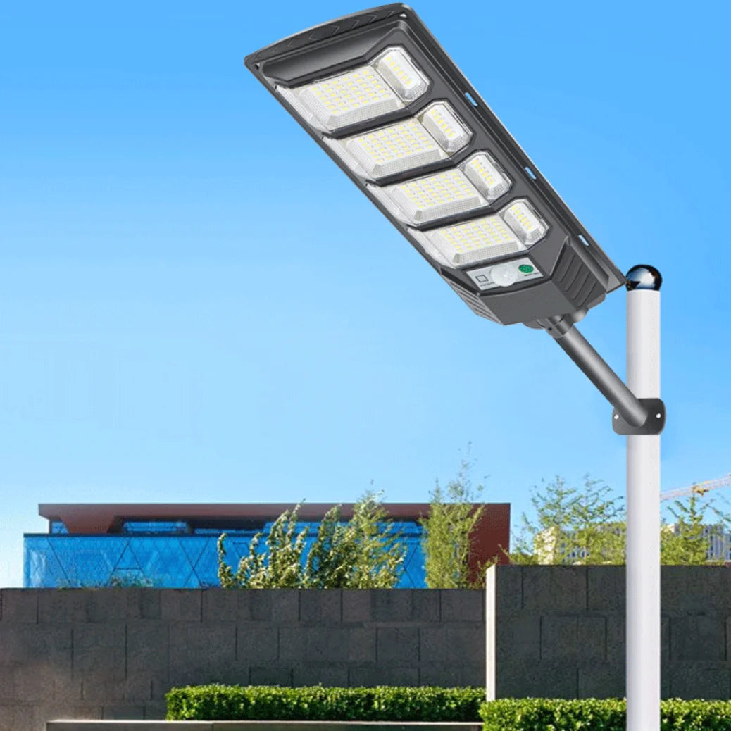 A modern solar street light fixture with multiple LED bulbs is mounted on a pole against a clear blue sky.