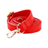 Red leather adjustable strap replacement with a gold-toned buckle coiled on a white background.