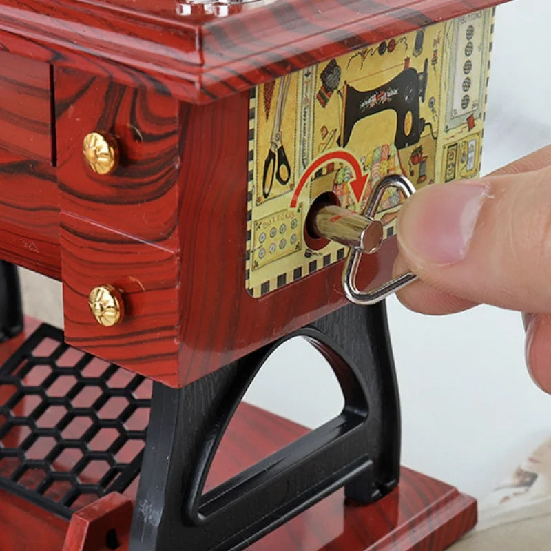A close-up of a vintage sewing machine music box with a wooden box featuring a keyhole and decorative elements.