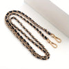 A gold-toned metal chain purse strap with a black leather cord and a secure clasp.
