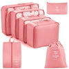 A set of pink travel packing cubes and storage organizer bags for clothing.