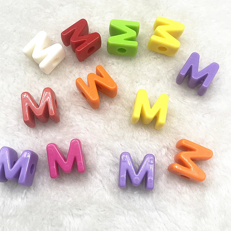 A collection of ten mixed alphabet letter beads in various colors including red, green, yellow, purple, and orange on a white
