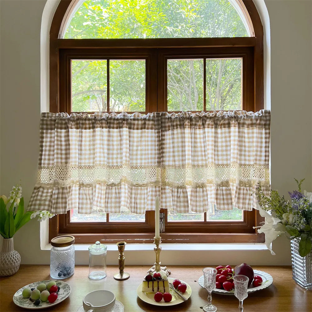 Beige gingham cafe curtain with crochet lace trim displayed in a wooden window frame.