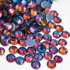 A close-up view of various iridescent and colorful hotfix rhinestones scattered on a white background.