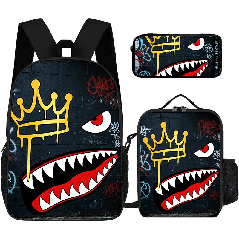 A set of three black backpacks featuring a graphic print of a crown and a shark's mouth.