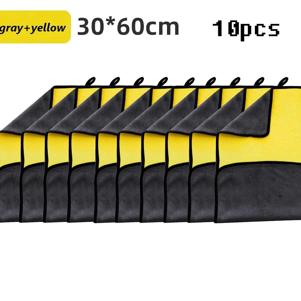 A set of ten gray and yellow microfiber car cleaning towels laid out in a row.