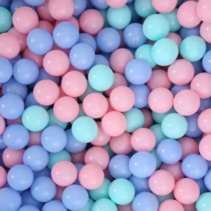 A close-up view of a large pack of colorful, non-toxic ball pit balls in various shades of pink, blue, and teal.