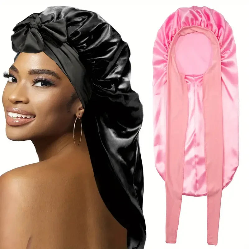 Ein schwarzer Satin-Schlafhut und ein rosa Satin-Schlafhut nebeneinander