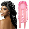 Schlafhaube aus schwarzem Satin und eine pinke Schlafhaube aus Satin nebeneinander.