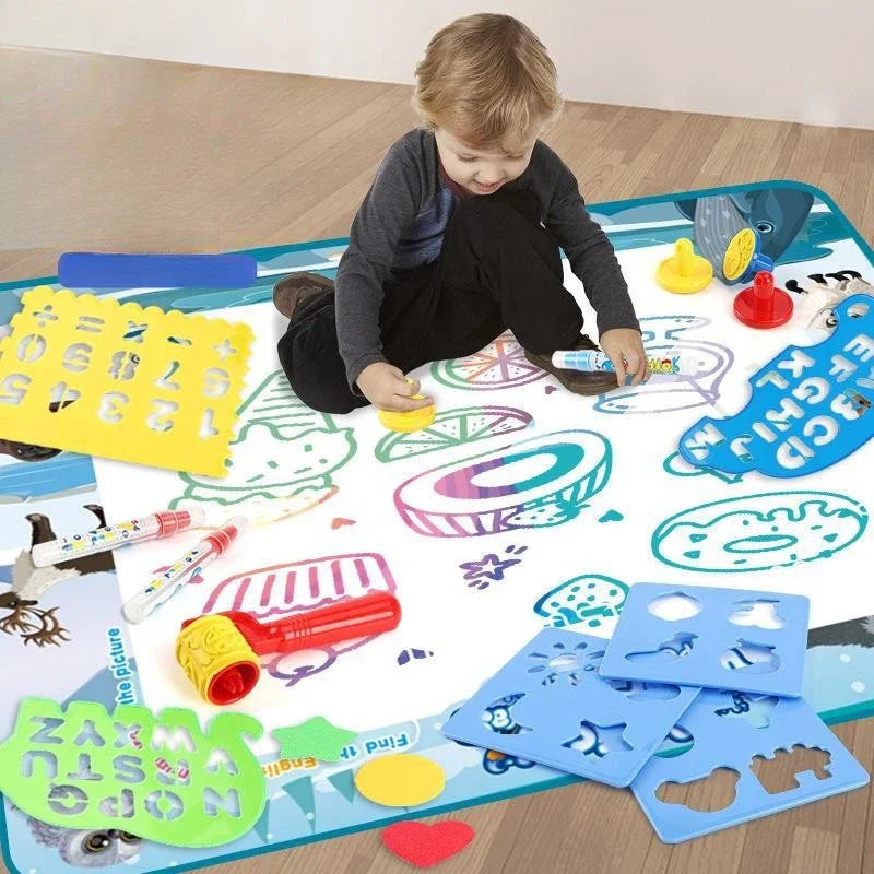 A child is using a large reusable water drawing mat with magic pens and various shapes to create art.