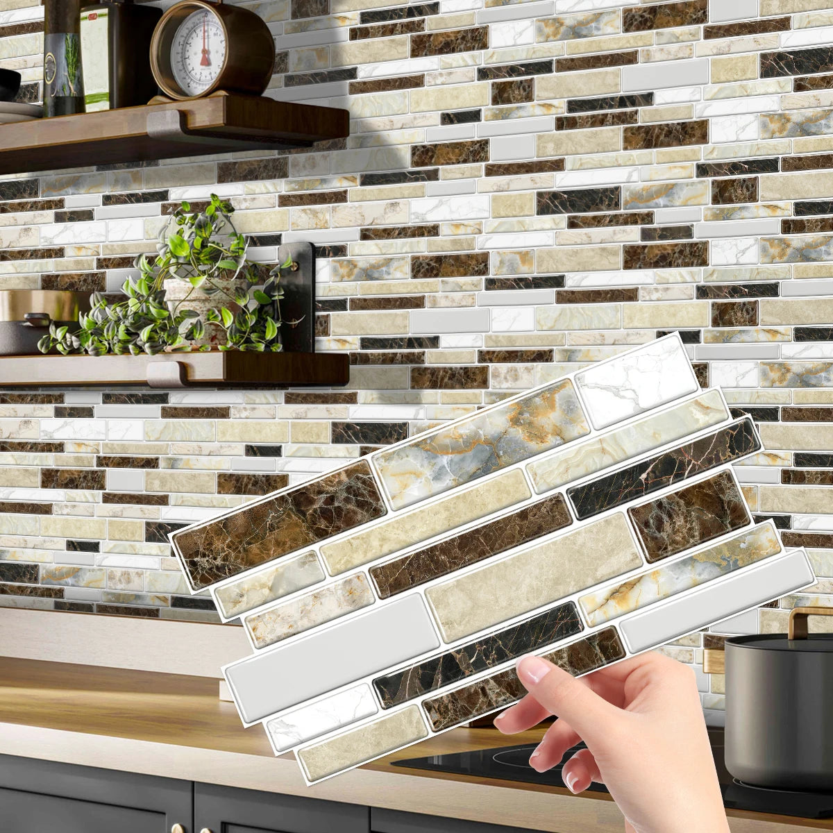 A hand is placing peel-and-stick tile stickers onto a kitchen backsplash made of marbled stone tiles.